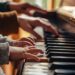 Aikuisen ja lapsen kädet soittavat pianoa lämpimässä sisätilassa
