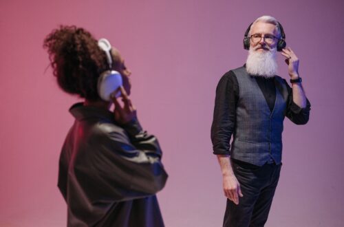 Kaksi henkilöä kuuntelee musiikkia kuulokkeilla violetissa tilassa